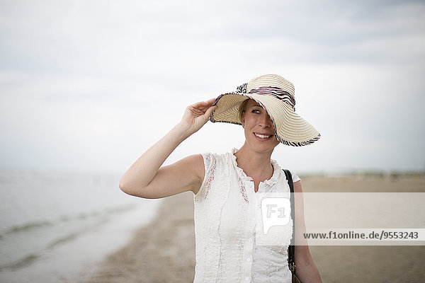 Niederlande  Noordwijk  lächelnde Frau mit Strohhut am Strand