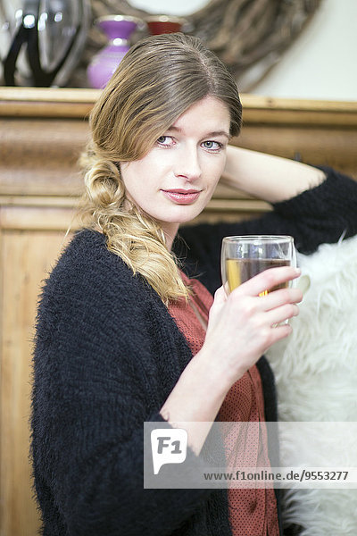 Porträt einer entspannten Frau mit Getränk zu Hause