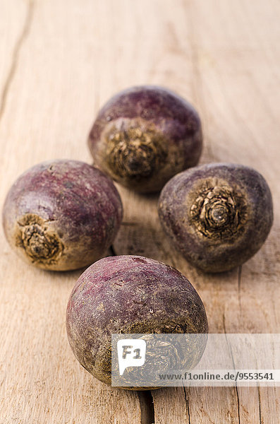 Four beetroots on wood