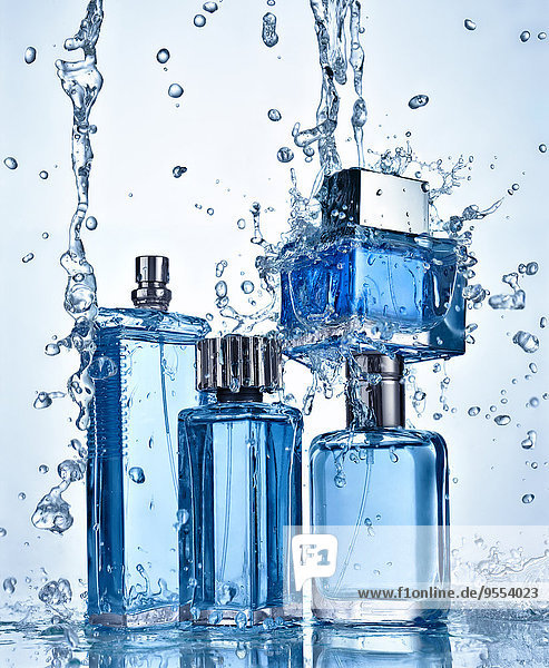 Vier Parfümflaschen unter fließendem Wasser