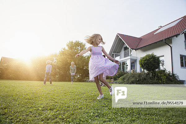 Girl in motion with family in garden