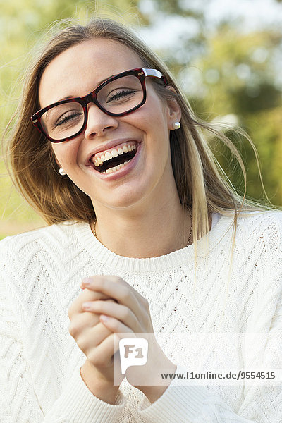 Porträt eines lachenden blonden Teenagermädchens mit Brille