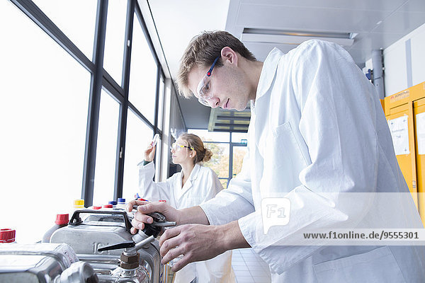 Junge Chemiker,  die in einem chemischen Labor arbeiten