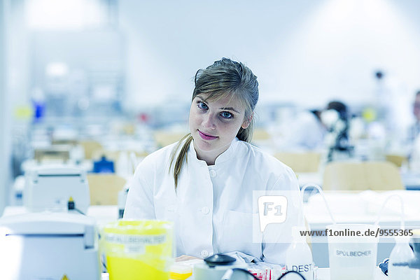 Porträt einer lächelnden jungen Naturwissenschaftlerin im Labor für Mikrobiologie
