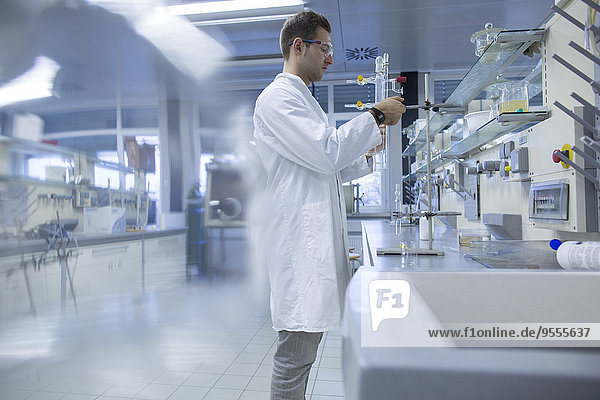 Chemiker im Labor beim Einsetzen der Glasbürette