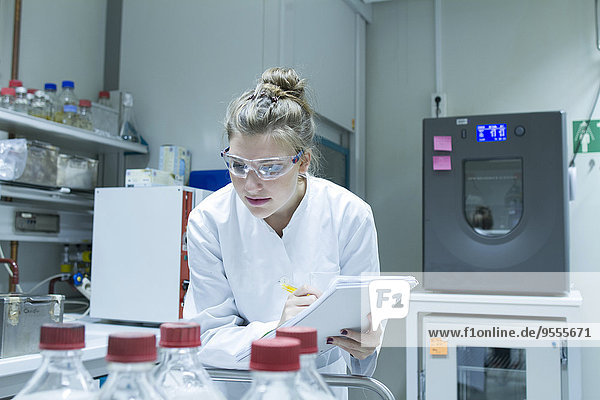 Biologe im Labor untersucht Lösungen in Flaschen