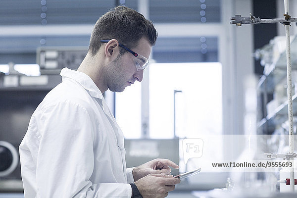 Chemiker im Labor mit digitaler Tablette