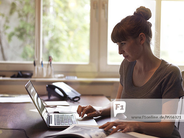 Frau am Schreibtisch mit Laptop