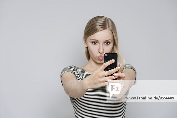 Portrait of young woman taking a selfie with smartphone