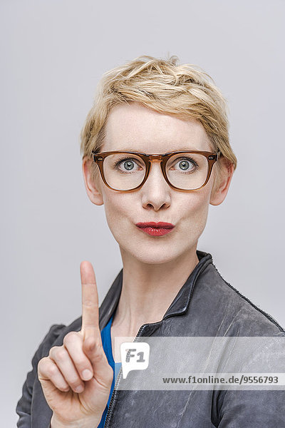 Porträt einer blonden Frau mit wedelndem Zeigefinger