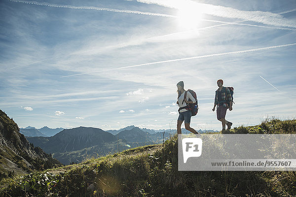Austria  Tyrol  Tannheimer Tal  young couple hiking on mountain trail