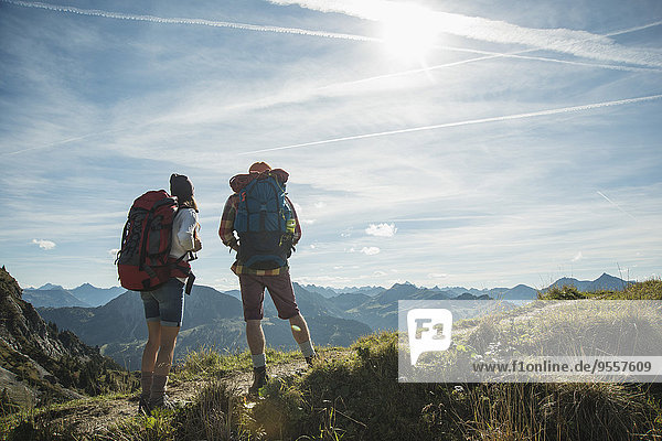 Austria  Tyrol  Tannheimer Tal  young couple standing on mountain trail
