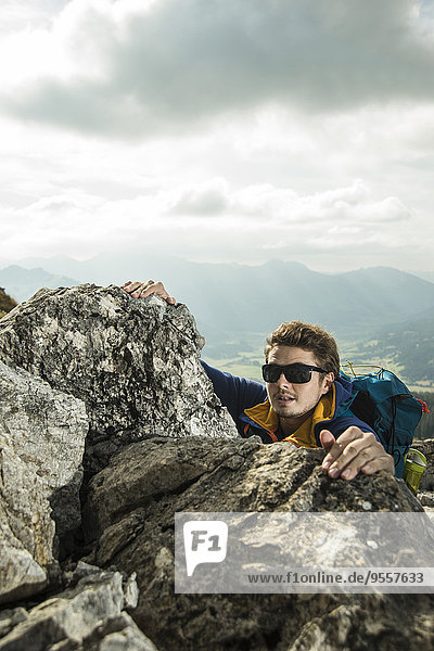 Österreich  Tirol  Tannheimer Tal  junger Mann beim Klettern am Fels
