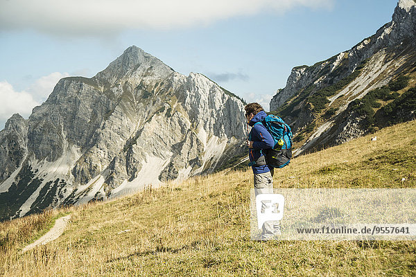 Austria  Tyrol  Tannheimer Tal  hiker with backpack on alpine meadow