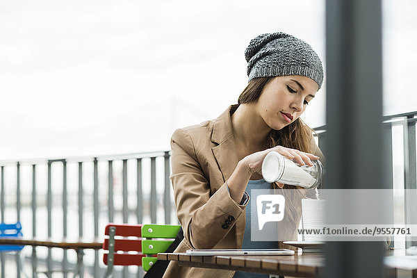 Junge Frau sitzend in einem Straßencafé