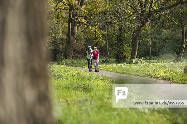 Senior woman and granddaughter walking together in a park
