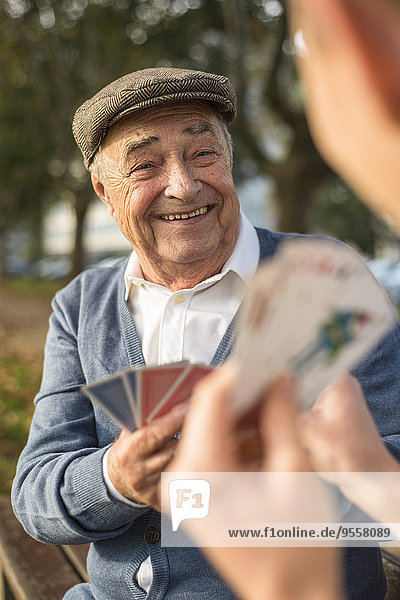 Senior Mann und Enkel beim Kartenspielen