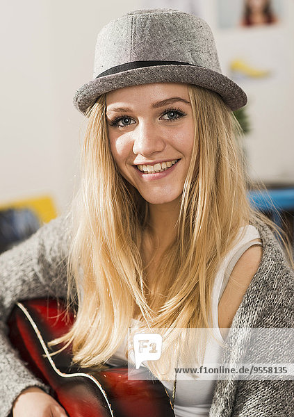 Portrait of smiling blond female teenager wearing hat