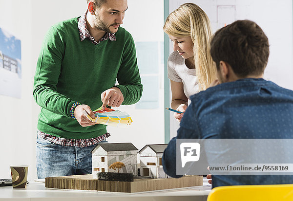 Drei junge Architekten im Büro bei der Diskussion