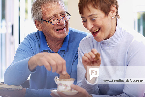 Fröhliches Seniorenpaar trinkt Kaffee zu Hause