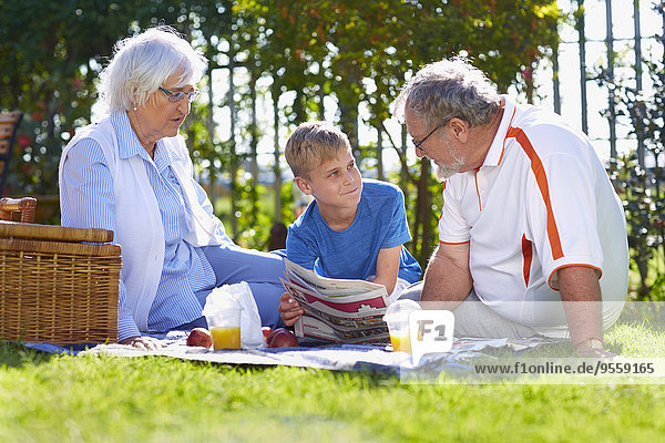 Großeltern mit Enkel beim Picknick im Park