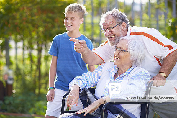 Großvater und Enkel mit Großmutter im Rollstuhl
