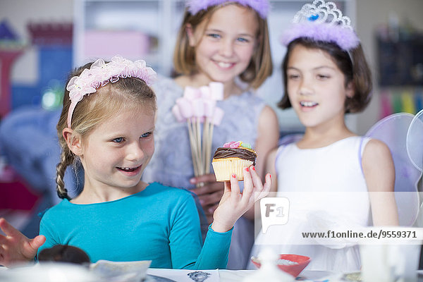 Girl holding cupcake on a birthday party