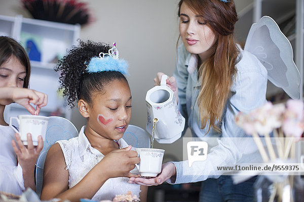 Girls and teenage girl on a tea party