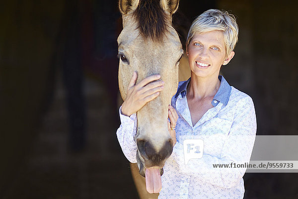 Porträt einer lächelnden Frau mit Pferd