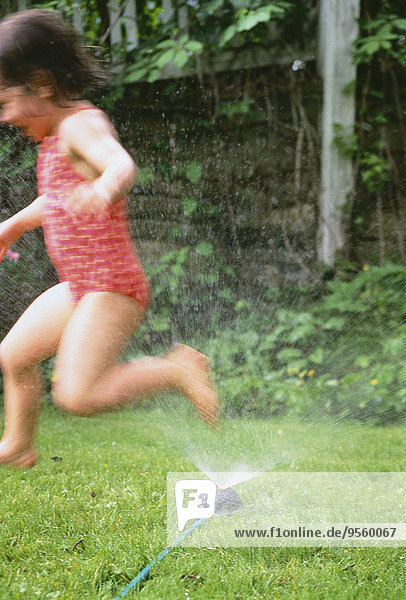 Girl in Swimwear  Playing in Sprinkler