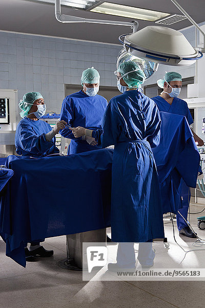 Ein OP-Team  das einen Patienten in einem Operationssaal operiert.