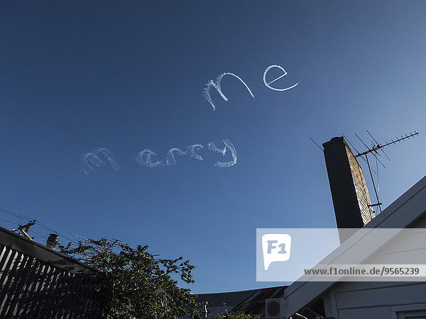 Low angle view of MARRY ME written by vapor trails against blue sky