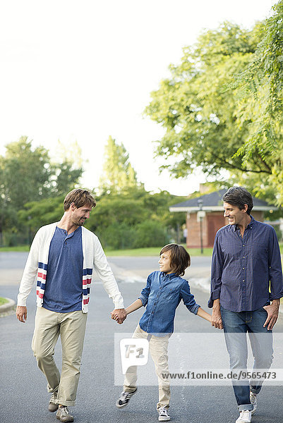 Junge  der mit seinen Vätern im Freien spazieren geht.