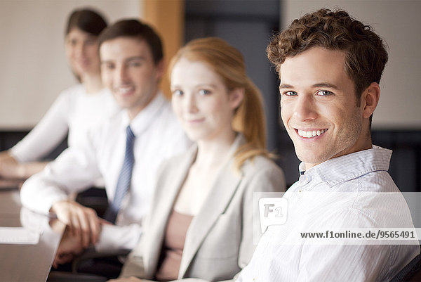 Young business professionals seated in conference room