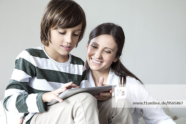 Mutter und Sohn verwenden gemeinsam ein digitales Tablett