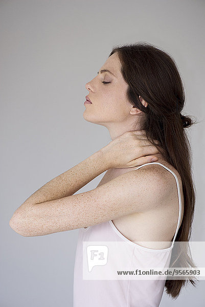 Woman rubbing neck  side view