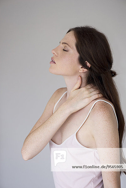 Woman massaging neck  side view