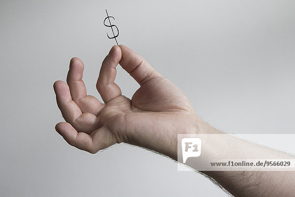 Beschnittenes Bild der Männerhand mit Dollarzeichen vor grauem Hintergrund