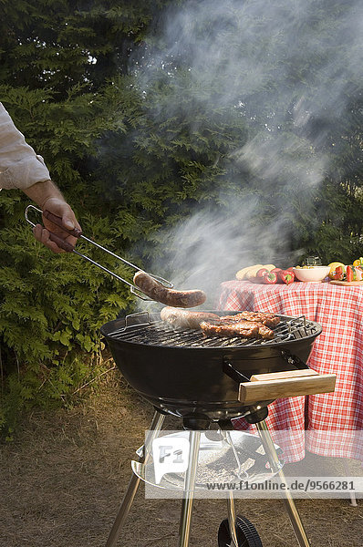 Man cooking meat on a barbeque grill