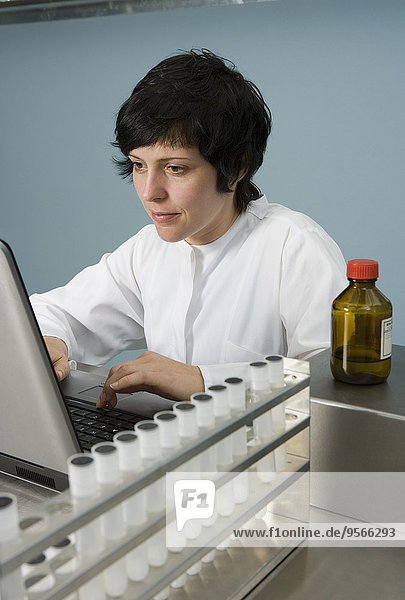 Technician working on laptop in laboratory