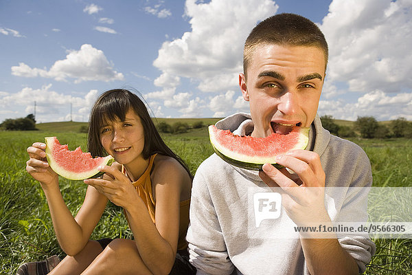 Junges Paar isst Wassermelone im Feld