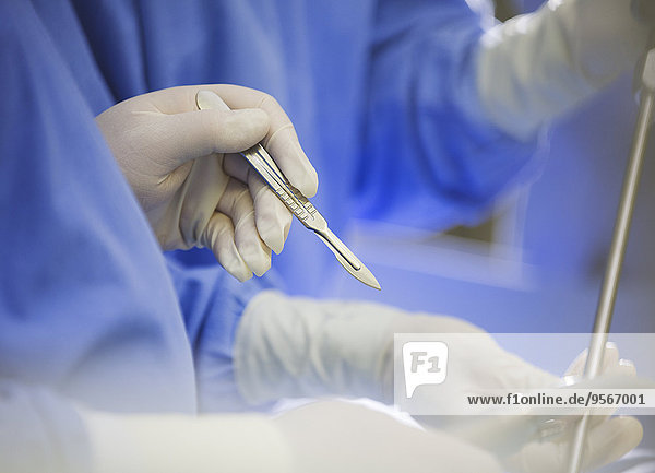 Reife Chirurgin mit Skalpell während der Operation