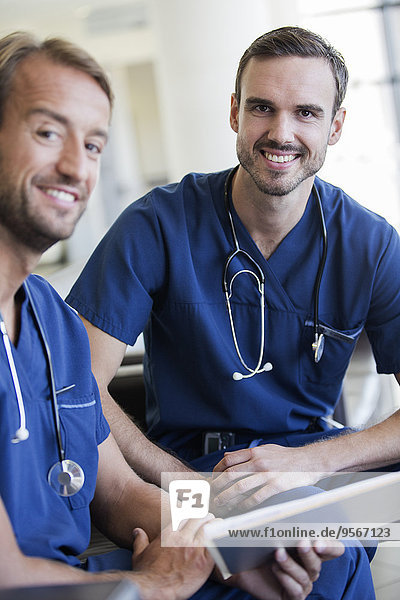 Portrait of two doctors with stethoscopes around necks in hospital