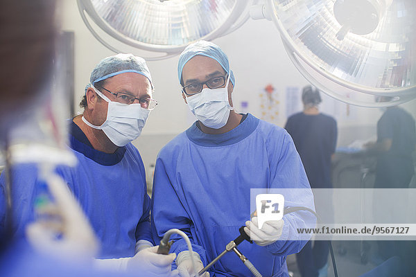 Portrait of doctors performing laparoscopic surgery in operating theater