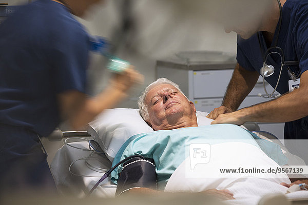 Senior patient receiving medical treatment in intensive care unit