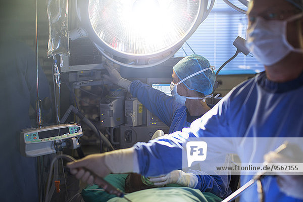 Male and female surgeons performing laparoscopic surgery in operation room
