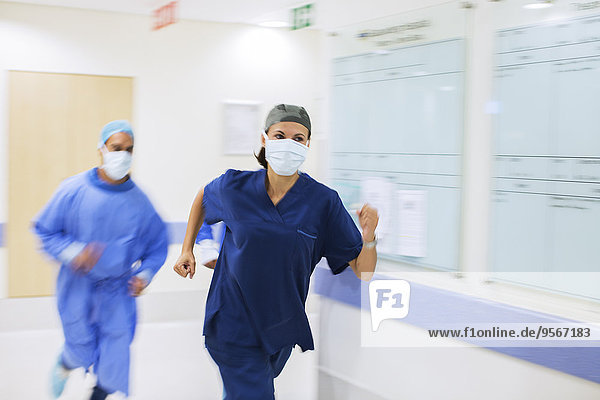 Medizinisches Personal mit Peelings und chirurgischen Masken im Krankenhausflur