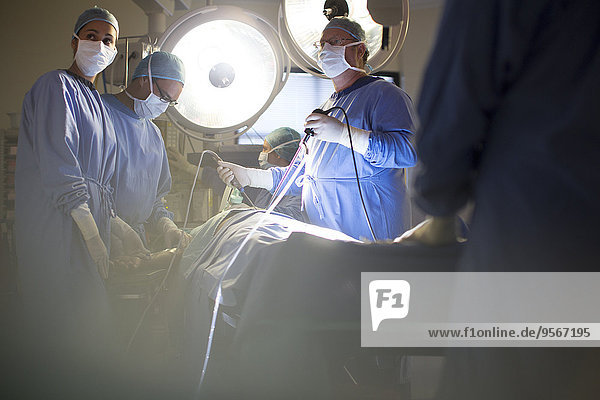 Team of doctors performing laparoscopic surgery in operating theater