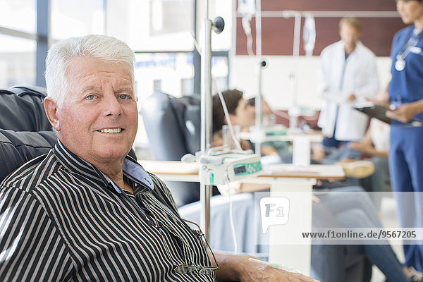 Smiling senior man undergoing medical treatment in outpatient clinic