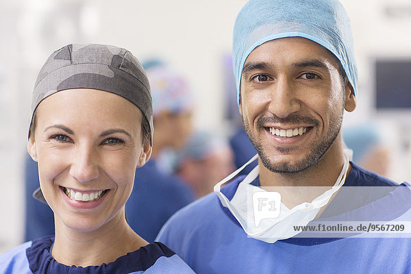 Portrait of smiling doctors wearing surgical caps in operating theater